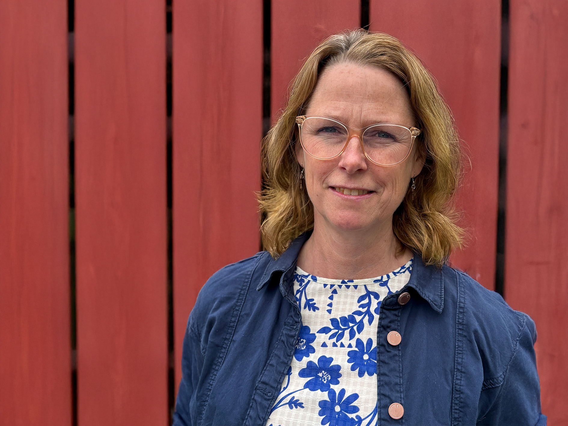 Kvinna framför röd vägg