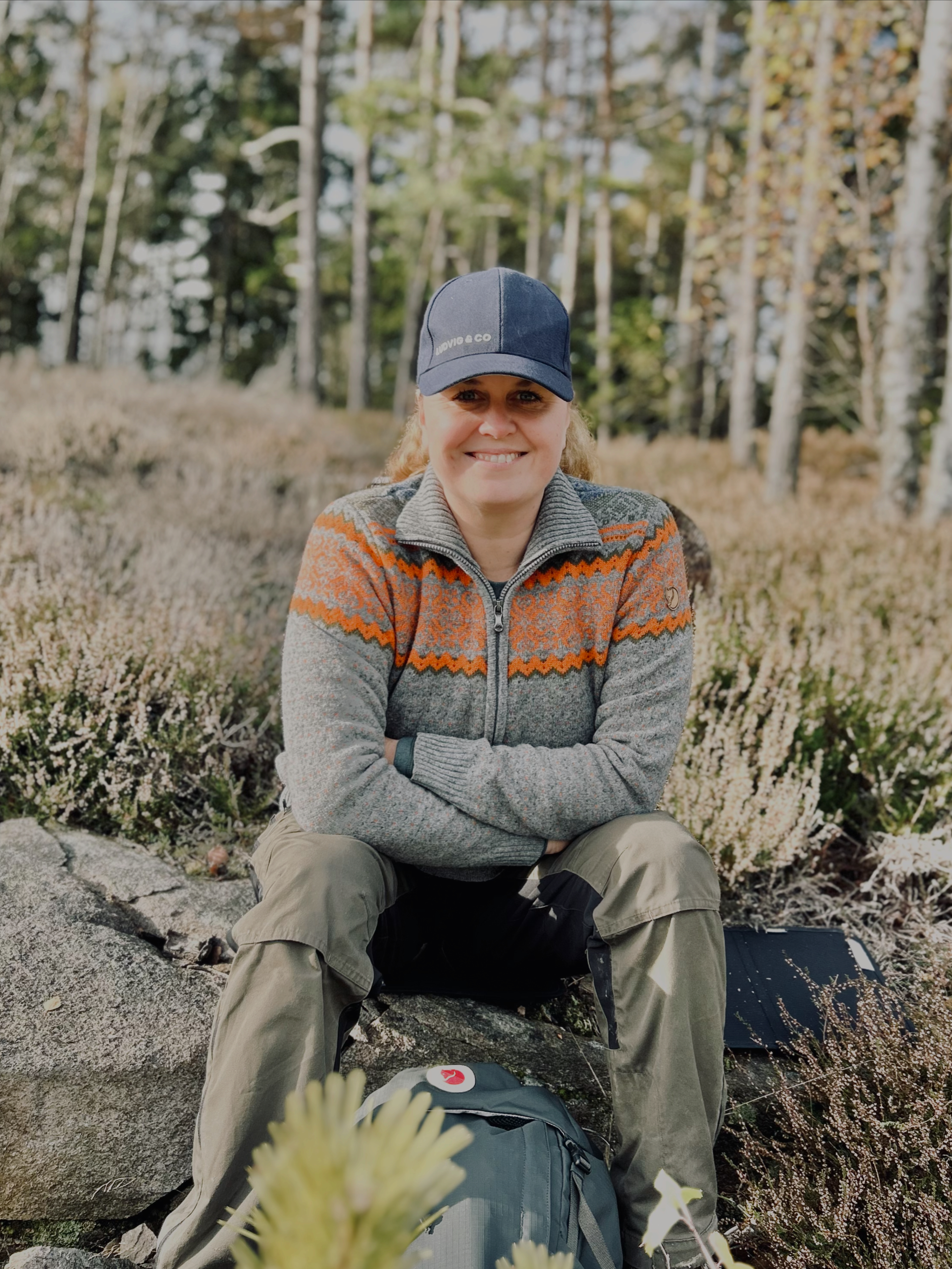 Jennie Bråthén, sittandes på en sten i skogen